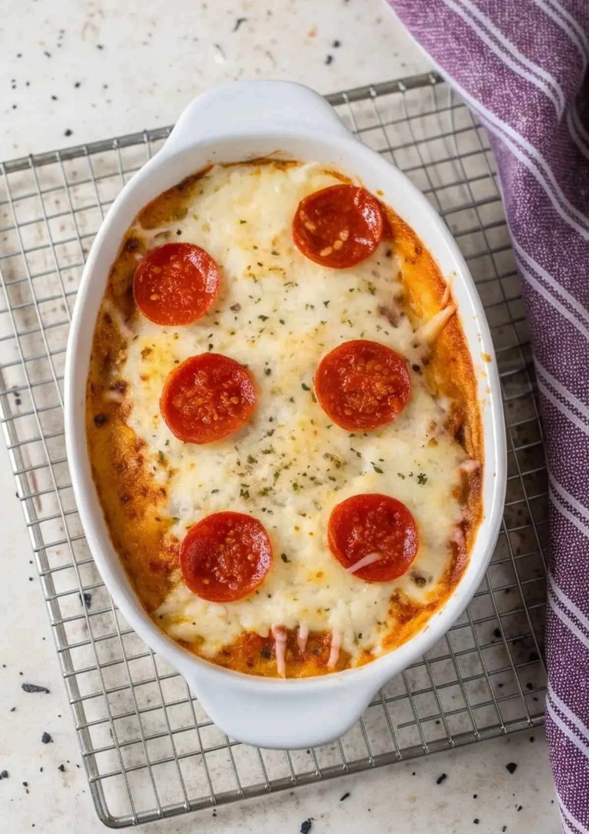 Creamy cottage cheese pizza bowl topped with pepperoni and melted mozzarella in a baking dish