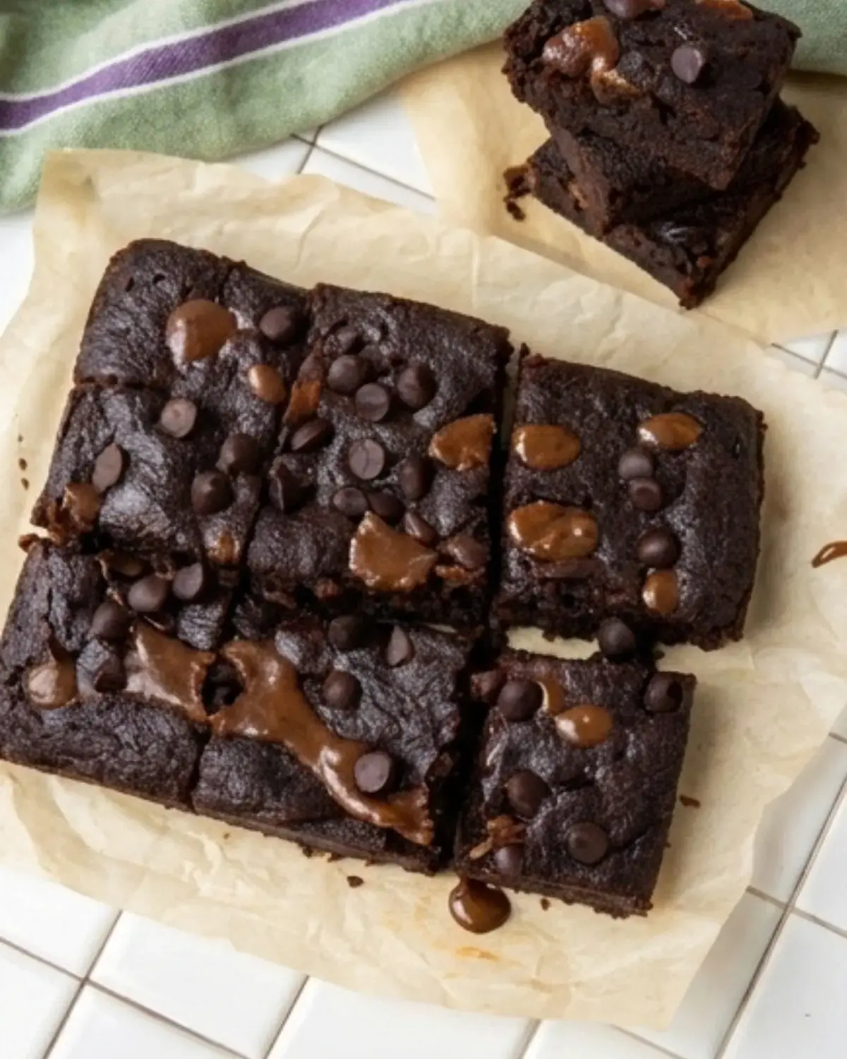 Overhead view of cottage cheese protein brownies cut into squares on parchment paper